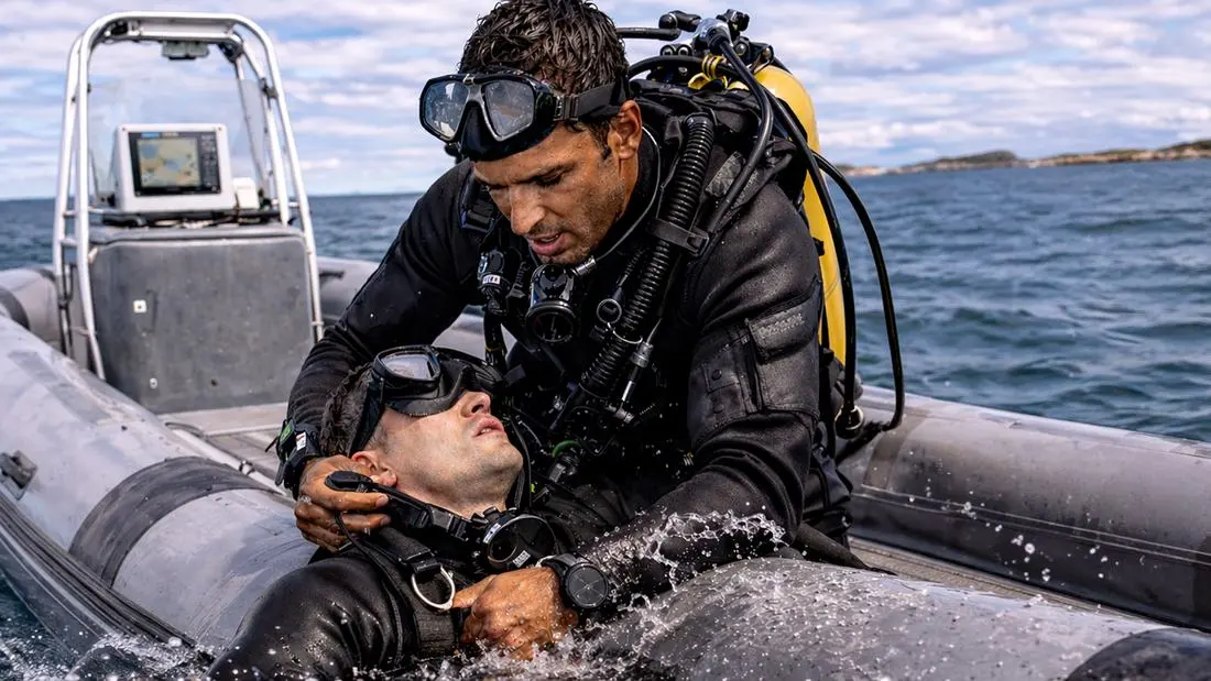 Plongeur secourant un équipier à bord d'un semi-rigide — premiers secours en milieu maritime